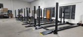 Tuxedo/Valor VP8K-DX 8,000 lb 4 Post Deluxe Storage Lift - 5 of them arranged pleasantly in a line in a warehouse.