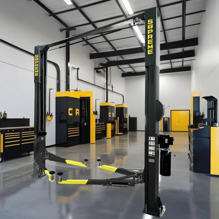 Supreme SP-10CFX 10,000 lb Clear Floor 2 Post Car Lift shown inside a yellow and black branded mechanic garage/shop