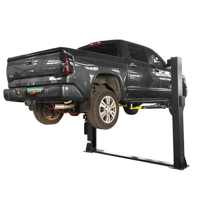 Supreme SP-10FP 10,000 lb Floor Plate 2 Post Car Lift on a white background with black pickup truck lifted to utmost height showing from the rear view